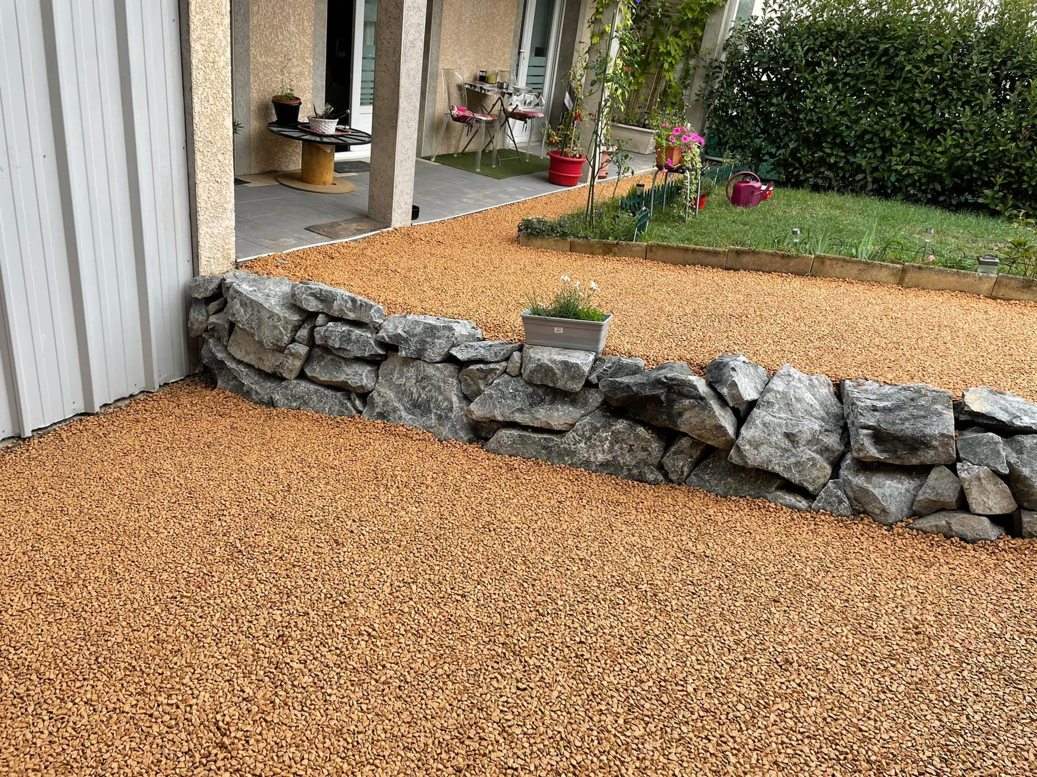 Chemin de cailloux avec muret en pierre après